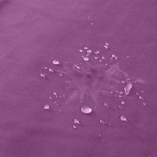 Water droplets scattered on a Liberator Fascinator Throw Velvety Purple waterproof sex blanket, creating a random pattern of wet spots and lines.