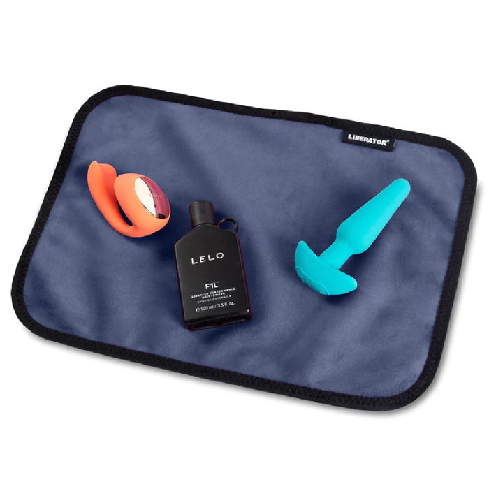 Liberator Fascinator Toy Pad Mini Waterproof Sex Blanket - Blue with toys and lube on it 