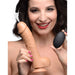 A woman with dark hair and a nose ring smiles while holding the XR Brands Loadz 8.5 Inch Vibrating Squirting Dildo with Wireless Remote Control - Caramel in one hand and the wireless remote control in the other. The dildo appears to be releasing a white liquid at the top.