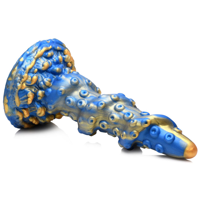 A Lord Kraken Blue and Gold 8.5 Inch Silicone Dildo by XR Brands, featuring bulbous forms and rounded protrusions reminiscent of a fantastical sculpture, lies horizontally against a plain white background. The design boasts a blend of metallic hues and organic shapes with a premium silicone finish.