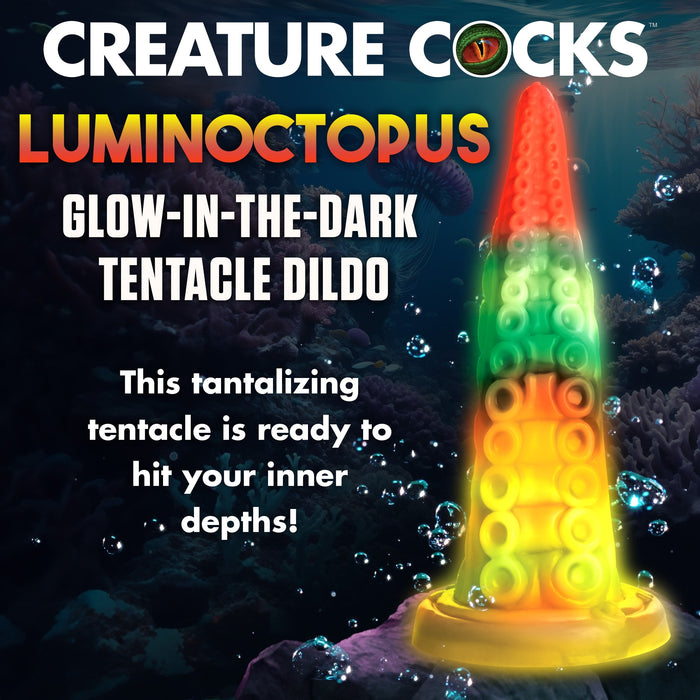 An enchanting, glow-in-the-dark tentacle-shaped adult toy is showcased underwater, encircled by bubbles and sea creatures. Text reads: "XR BRANDS LUMINOCTOPUS GLOW-IN-THE-DARK TENTACLE DILDO. Made from premium silicone, this tantalizing tentacle is ready to explore your inner depths!