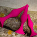 Three pink, body-safe silicone, cone-shaped items of varying sizes from the Blush Luxe Beginner 3 Plug Anal Trainer Set are resting on a piece of tree bark. They have a curved, ergonomic design and are uniformly colored. The texture of the bark is rough with patches of green and yellow lichen.