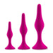 Three different-sized pink silicone butt plugs from the Luxe Beginner 3 Plug Anal Trainer Set by Blush are shown in a line, from smallest to largest. Each plug, crafted from satin smooth silicone, features a tapered tip, a narrow neck, and a flared base for safety and easy retrieval.