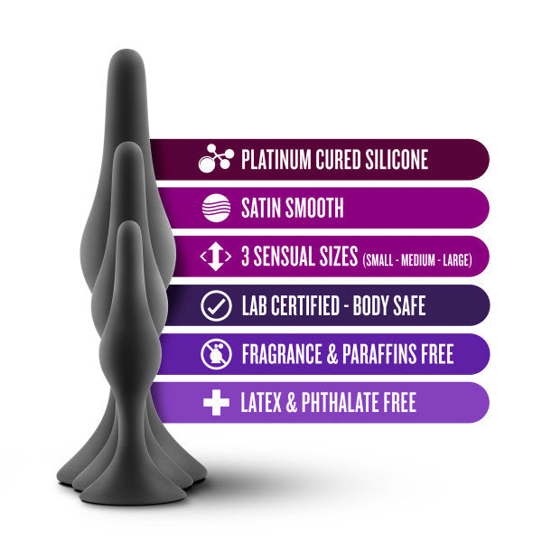 A promotional image showcasing three grey silicone anal plugs from the Luxe Beginner 3 Plug Anal Trainer Set by Blush, highlighting their features: Platinum Cured Satin Smooth Silicone, Suction Cup Base, 3 Sensual Sizes (Small, Medium, Large), Lab Certified - Body Safe, Fragrance & Paraffins Free, and Latex & Phthalate Free.