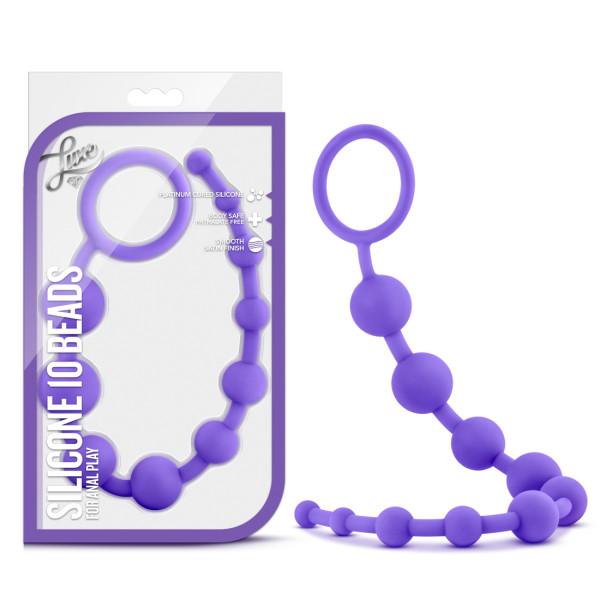 A product image displays the Luxe Beginner Ultra Slim Silicone Anal Beads in purple, crafted by Blush for anal play. The body-safe beads are organized in ascending size order and feature a loop handle at one end. The item is shown both inside and outside its plastic packaging, which includes detailed product information.