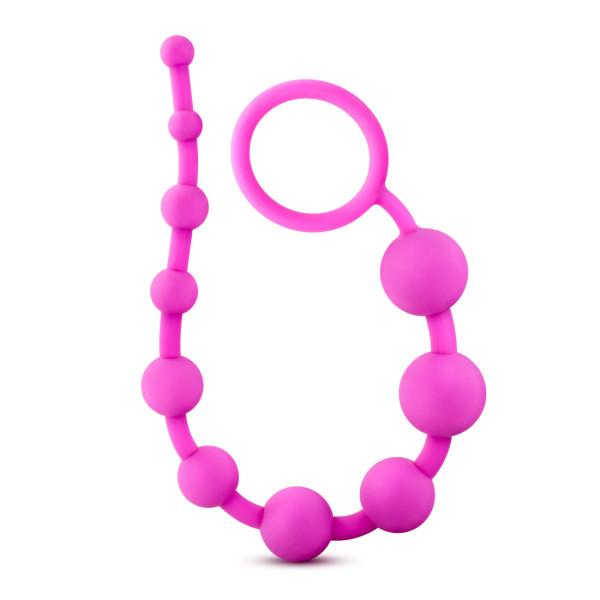 The Luxe Beginner Ultra Slim Silicone Anal Beads by Blush come in various colors and feature body-safe pink silicone beads that progressively increase in size, starting small and attached to a looped handle at one end for easy use.