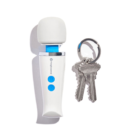 The Magic Wand Micro Rechargeable Cordless Vibrator by Vibratex, featuring a compact white design with a blue power button and a smaller blue button, sits upright with its head facing up next to a keychain holding two silver keys. The keys are attached to a metal ring beside the massager.