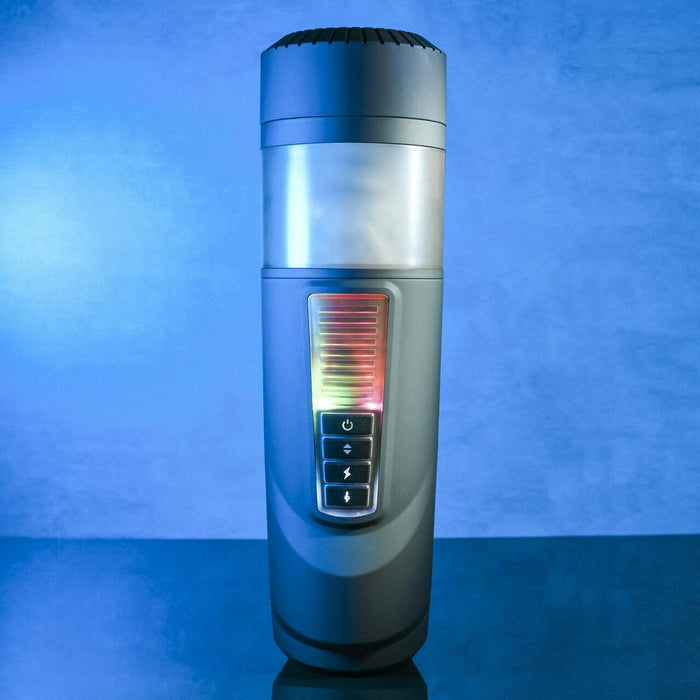 The Message in a Bottle Thrusting Spinning Stroker with Voices & Mount by Evolved Novelties is showcased against a blue background. Its sleek, cylindrical design features a glowing vertical display that shows colored bars and multiple buttons for 7 speeds and functions. The device's upper part has a translucent section, while the top boasts a solid, textured grip.