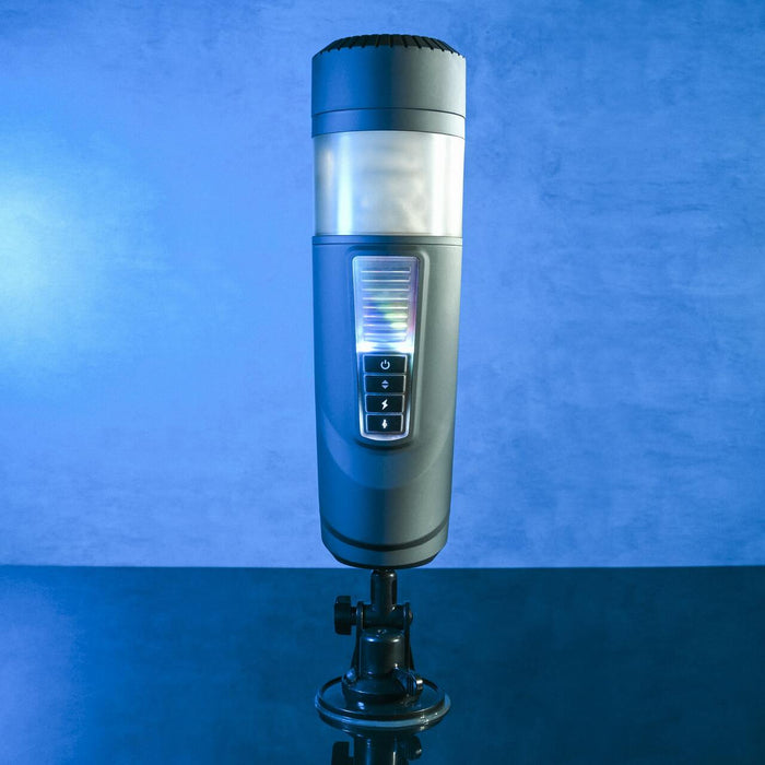 Against a blue background, the Message in a Bottle Thrusting Spinning Stroker with Voices & Mount from Evolved Novelties is showcased on a compact black stand. The sleek, cylindrical design features an illuminated control panel on the front, displaying various buttons and indicators to offer 7 speeds and functions for optimal performance.