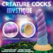 Promotional image for XR Brands' "Mystique Thick 8 Inch Silicone Unicorn Dildo." This unicorn horn dildo showcases a swirled, vibrant purple and blue design with a flared yellow base. It's tapered for easier insertion, crafted from premium silicone, harness compatible, phthalate-free with a strong suction base. Set against a colorful, fantasy-inspired landscape with a starry sky.