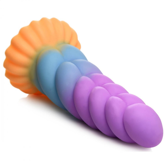 Introducing the Mystique Thick 8 Inch Silicone Unicorn Dildo by XR Brands. This silicone fantasy dildo boasts a vibrant, gradient design that transitions seamlessly from orange and blue at the base to purple at the tip. Its ribbed, textured surface adds an extra layer of pleasure, while the flared base ensures safe use.