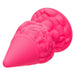 Close-up image of the Naughty Bits Girthy Pink Gnome Butt Plug by CalExotics, crafted from pink silicone. This unique butt plug boasts a smooth, conical tip and a base adorned with intricate, brain-like textures for a truly fulfilling playtime experience.