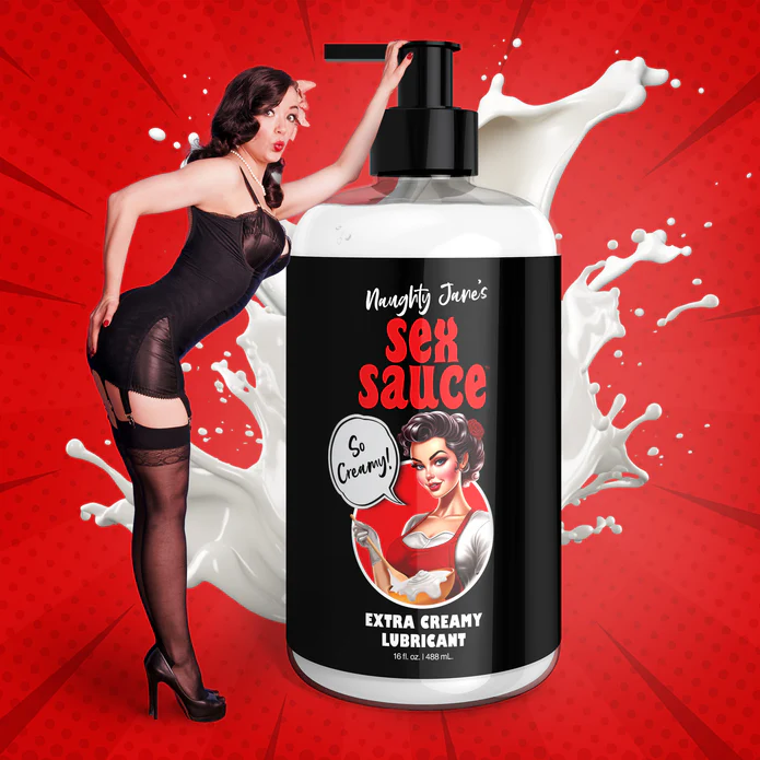 A bottle of "Naughty Jane's Creamy Cum Sex Sauce Lubricant 16oz" from XR Brands features a retro-style woman in red on the label. A real woman dressed in black lingerie poses next to the body-safe lubricant against a red background with splashes of white liquid. The text on the label reads "So Creamy!".