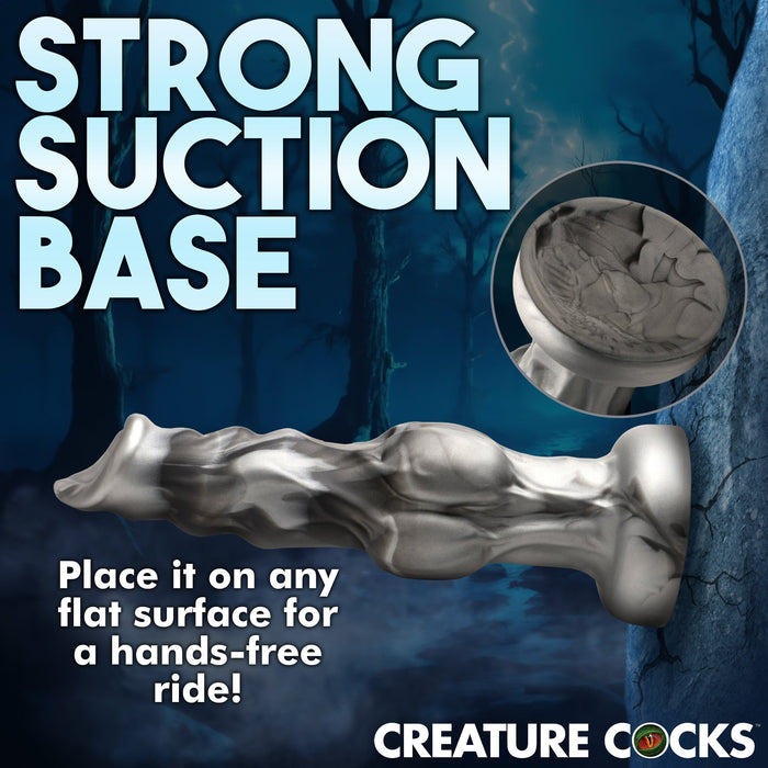 An image showing the Night Prowler 10 Inch Werewolf Canine Dildo with Knot from XR Brands, featuring a silver werewolf design and a strong suction cup base against a nighttime forest background. The text reads "STRONG SUCTION BASE" at the top, with a close-up inset highlighting the base. Additional text says, "Place it on any flat surface for a hands-free ride!" and "CREATURE COCKS" at the bottom.