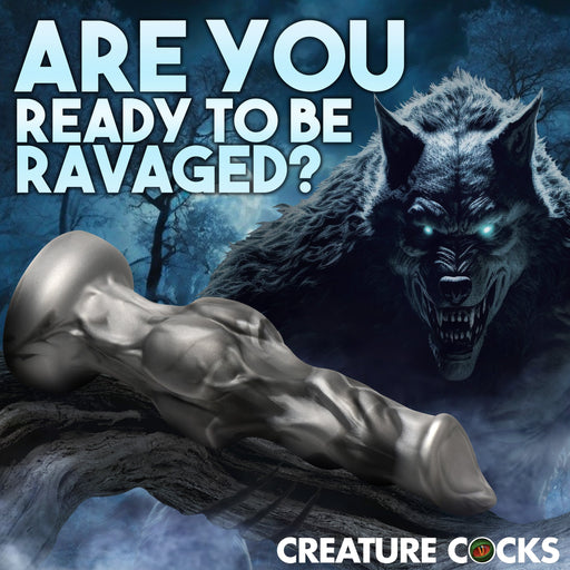 A promotional image featuring a detailed, fantasy-themed Night Prowler 6.75 Inch Werewolf Canine Dildo with Knot by XR Brands in the foreground with the text "ARE YOU READY TO BE RAVAGED?" in bold letters. Behind the text, an illustration of a menacing werewolf in a dark, eerie forest is visible. The caption reads "CREATURE COCKS.