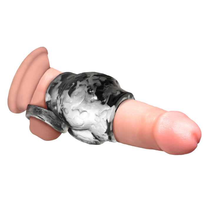 A close-up image of the XR Brands Night Prowler Alpha Wolf Knot Girth Enhancer with Ball Strap, a realistic artificial penis made from body-safe silicone, featuring a black and white camouflaged strap-on harness securely attached around it. The harness extends to a loop at the base, designed for a comfortable fit.