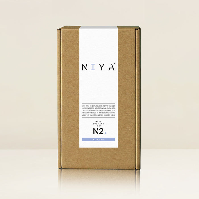 A brown cardboard box featuring a minimalistic design and labeled "Rocks Off" stands upright against a plain, light-colored background. The bottom part reads "Niya N2 Powerful Textured Solo and Couples Vibrator" and includes details about its ergonomic curve for enhanced user comfort.