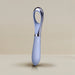 The Niya N3 Easy Grip Finger Loop Bullet Vibrator by Rocks Off features a sleek, modern design with a light blue silicone handle and a reflective metallic finger loop vibrator at the top. Specifically designed for clitoral stimulation, this waterproof device stands upright against a neutral beige background.