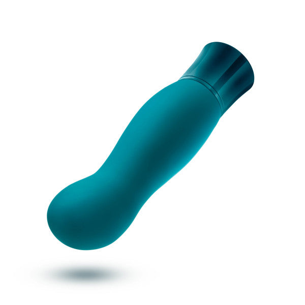 The Oh My Gem Fierce Blue Topaz Warming G-Spot Vibrator by Blush is a teal, cylindrical, battery-powered personal massager designed for g-spot exploration with a curved, contoured design and a rounded tip. It features a smooth, seamless surface and a slightly wider base with a darker hue for grip. The massager is isolated against a white background.