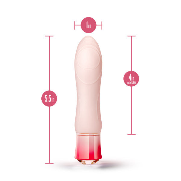 The Oh My Gem Morganite Warming Beginner Mini Vibrator by Blush, a light pink, cylindrical vibrator, is shown against a white background with measurements. It is 5.5 inches in total length, 4 inches insertable, and has a diameter of 1 inch. The base is red and translucent with a faceted design and offers multiple vibrating functions.