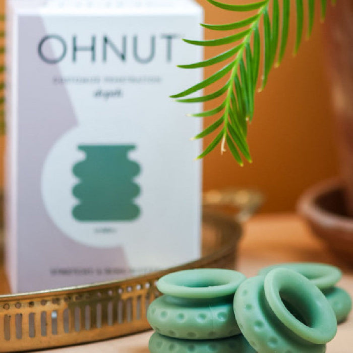 Ohnut Wide Set of 4 Wearable Penetration Adjustment Rings and box with plant in background 