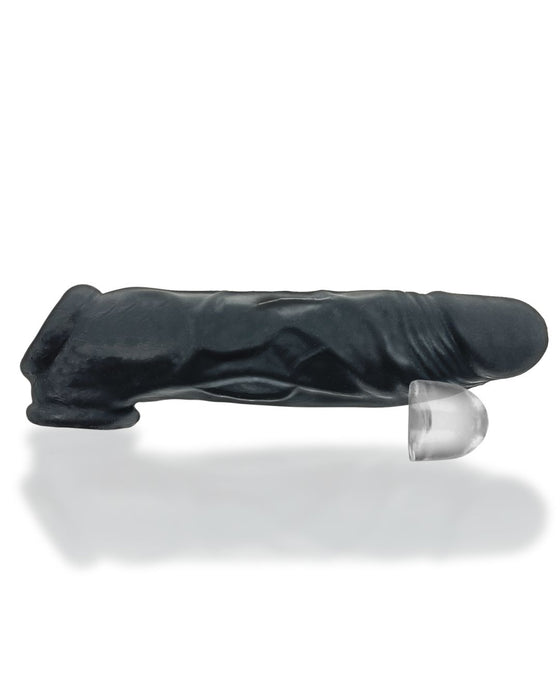 A realistic black dildo with detailed textures and a suction cup base is shown lying on a white surface. The Oxballs Dicker 7.5 Inch Cock Sheath - Black Ice by Oxballs is made from Plus+SILICONE, with the translucent suction cup base ensuring a secure attachment.