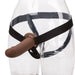 Two transparent glasses, one nested inside the other, with a black strap securing a CalExotics PPA with Jock Strap Hollow Silicone Penis Extender Strap-on - Chocolate between them.