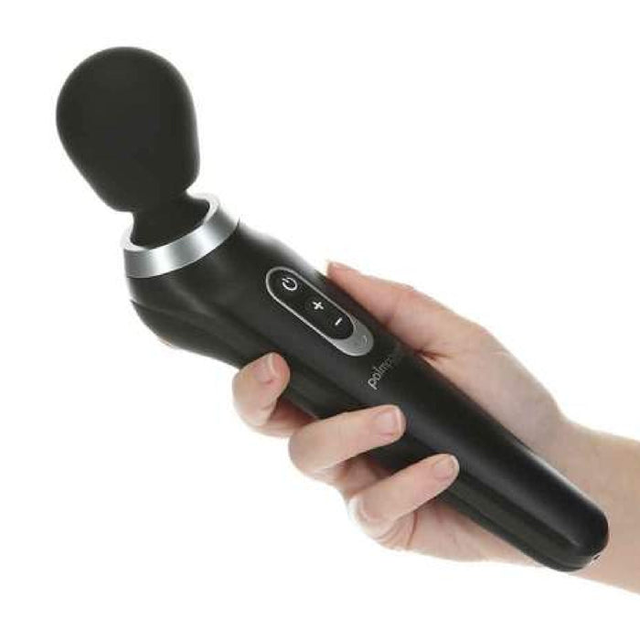 A hand holding the Palm Power Extreme Rumbly Ergonomic Wand Vibrator by BMS Enterprises, with buttons for power, plus, and minus on the handle. The massager, crafted from medical grade silicone, features a rounded head and a sleek design.