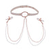 The Peaches 'n Cream Collar and Nipple Clamps by Sportsheets features a white leather collar adorned with rose gold hardware and a central metal ring. Elegant chains extend from the ring to adjustable rubber-tipped clamps, combining both style and practicality. Ideal for anyone looking to add a sophisticated flair to their accessories.