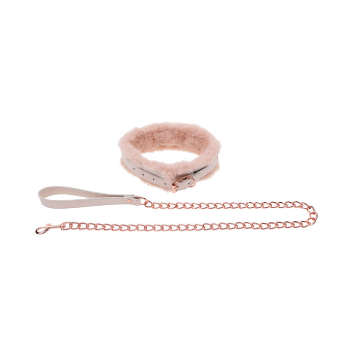 The Peaches 'n Cream Fur Collar and Leash by Sportsheets is a plush pink collar featuring a buckle and a detachable rose gold chain leash, ideal for subtle bondage in intimate settings. It includes a wrist loop handle for convenience, with both the leash and collar displayed gracefully against a plain white background.