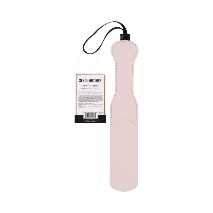 A blush-colored Peaches 'n Cream Impression Paddle, crafted from faux leather and featuring a black wrist strap, is displayed against a white background. A product tag labeled "Sportsheets" is attached, perfect for those looking to explore impact play.