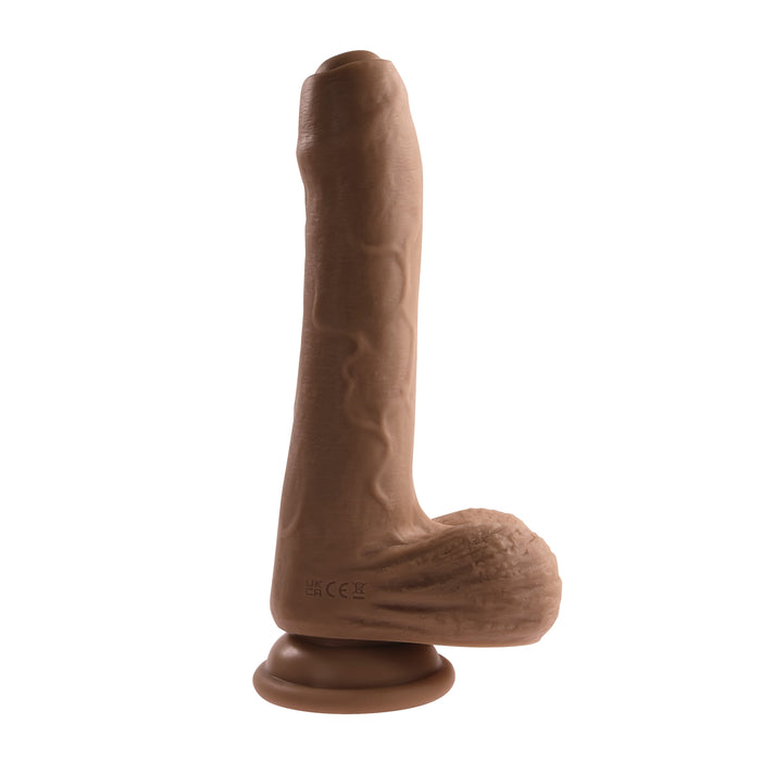 A realistic, waterproof Peek A Boo Uncut Vibrating 8" Silicone Caramel Dildo from Evolved Novelties, designed to resemble an erect penis with textured veins and detailed testicles, complete with a suction cup base.