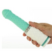 A hand holds the Pillow Talk Feisty Thrusting Vibrator with Case from BMS Enterprises against a plain background. The USB rechargeable vibrator features a teal and white diamond-patterned texture, with the bottom part in white, separated from the teal upper section by a metallic ring.