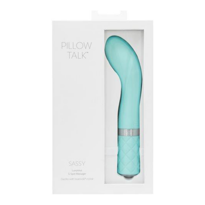 A teal Pillow Talk Sassy Rumbly Rechargeable G-spot Vibrator from BMS Enterprises displayed in its white packaging. The massager, a high-quality waterproof vibrator, features a curved design and a textured handle. The packaging includes the brand name and model, with a window showing the product inside.