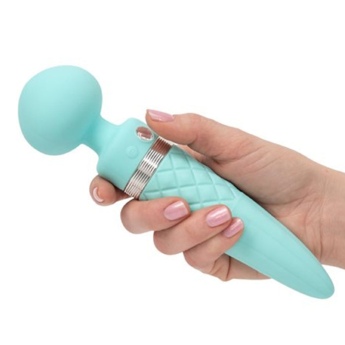 A person with manicured nails holds a Pillow Talk Sultry Warming Double Ended Wand Vibrator by BMS Enterprises in teal. USB rechargeable, it features a quilted texture on its handle and offers powerful rumbly vibrations via its rounded head.