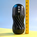 A Playboy Solo Rechargeable Sucking Vibrating Double Motor Masturbator by Evolved Novelties, a black, cylindrical electronic device with a textured grip and three buttons on the front, offering intense vibration, is situated next to a yellow measuring tape against a light blue background. The device stands about 8 inches tall and is USB rechargeable.