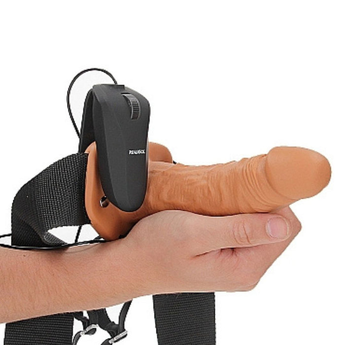 Realrock Vibrating 6 Inch Hollow Dildo & Strap-on Harness being held by a hand on a white background