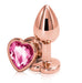 Introducing the Rear Assets Rose Gold Metal & Pink Gem Heart Anal Plug - Small by NS Novelties. This gold chrome-plated anal plug features a heart-shaped base adorned with a pink, faceted gemstone. It boasts a smooth, tapered design and a glossy finish, making it ideal for those who enjoy temperature play.