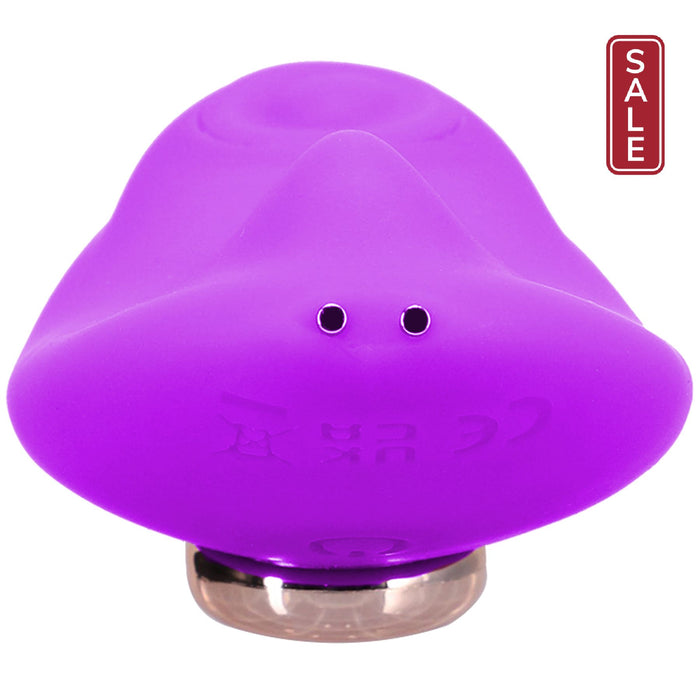 A vibrant purple Remote Controlled Panty Vibrator for Beginners in a Bag from Doc Johnson, features a smooth, abstract form that resembles a futuristic gadget or modern art piece. It has two small circular features on one side and sits on a reflective base. Subtle engraved markings and powerful vibrating functions add to its intriguing appearance.