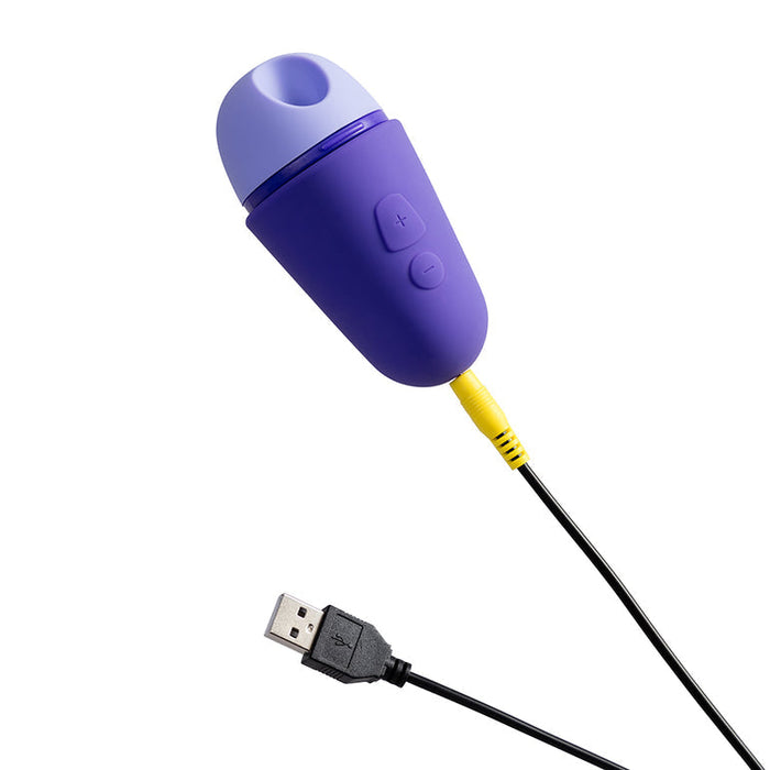 The Romp Free X Beginner's Pleasure Air Clitoral Stimulator with Lid by WOW is a small, purple and lavender rechargeable device that connects to a black USB cable with a yellow plug. It features two buttons marked with plus and minus symbols, making it perfect for those seeking a travel-ready solution.