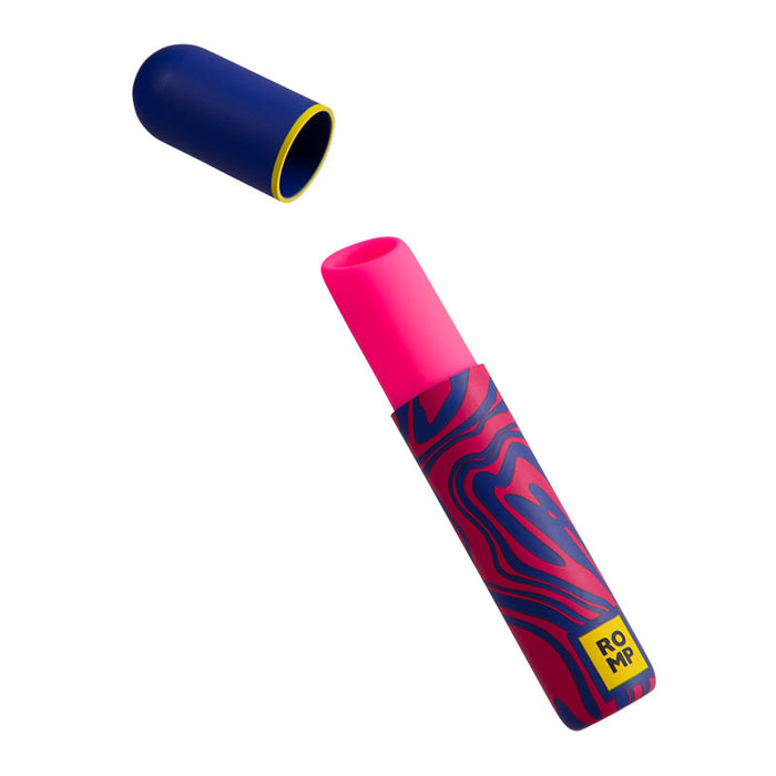 Image of the Romp Lipstick First Time Pleasure Air Clitoris Stimulator Vibrator by WOW, featuring a vibrant, swirly pink and blue cylindrical design. The product is partially open, revealing a pink component inside. The cap, which is blue with a yellow interior, is positioned above the product. The yellow logo reads "ROMP," known for its innovative Pleasure Air Technology.