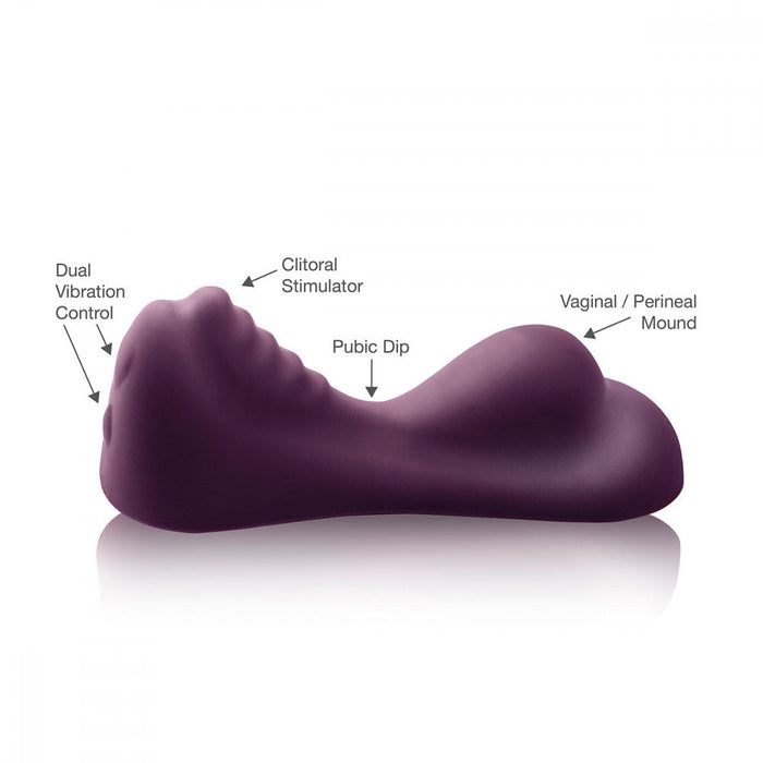 The Ruby Glow Ride On External Hands-Free Humping Vibrator by Rocks Off is a dark purple sex toy featuring "Dual Vibration Control," a "Clitoral Stimulator," a "Pubic Dip," and a "Vaginal / Perineal Mound." This non-penetrative humping vibe boasts a curved shape with distinct contours at each labeled area.