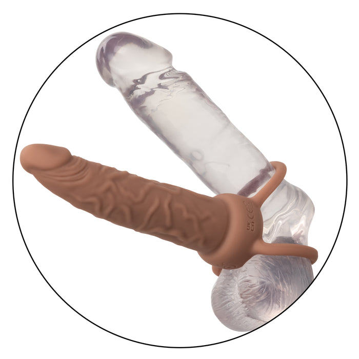 The Performance Maxx Double Penetration Vibrating Dildo in light chocolate offers a realistic double-ended design with a transparent, textured end, and a tan, ribbed end. Its secure harness ring makes it ideal for shared anal exploration.