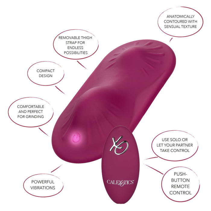 The Dual Rider Strap-on Grinding Pad with Remote Control by CalExotics is an ergonomically designed product in a purple hue, featuring anatomically-contoured texture and vibrating ridges. It includes a detachable thigh strap and a compact design for powerful vibrations, ensuring comfort while grinding. The set also comes with a matching purple wireless remote control.