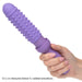 A hand holding a purple, cylindrical object with a bumpy, textured silicone sleeve. The text below reads "Removable textured silicone sleeve for added sensations" from the Dr. Laura Berman Vibrating Dilators Set of 4 by CalExotics.