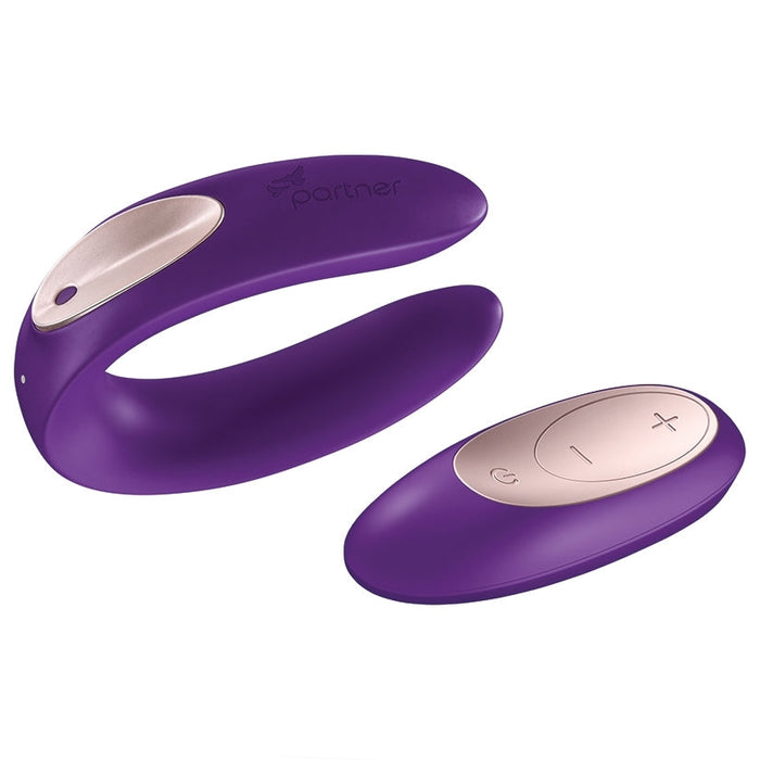 The Satisfyer Partner Plus Remote Wearable Couple's Vibrator by Satisfyer, a purple U-shaped device with a gold accent and the word "partner" engraved on one end, is displayed alongside its matching purple and gold remote control. This waterproof remote features three buttons for power and intensity adjustments, ensuring optimal clitoral stimulation.