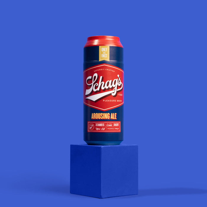 A tall can of Schag’s Arousing Ale Self-Lubricating Penis Stroker by Blush sits atop a blue platform against a blue background. The can features a red and blue label with text advertising the premium crafted ale, discretely hinting at the self-lubricating stroker pleasure.