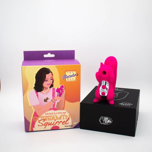 A boxed pink toy named the 'Screaming Squirrel Air Pulsation Clitoral and G Spot Vibrator' by Natalie's Toy Box, featuring an image of a woman on the packaging, is displayed alongside the toy, which is mounted on a black stand. The multi-function toy has a pink, squirrel-shaped design with a silver belly and a small protruding part.