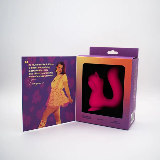 A Screaming Squirrel Air Pulsation Clitoral and G Spot Vibrator from Natalie's Toy Box is displayed in a pink packaging box with a transparent window. Beside the box, there is a standing card featuring an image of a woman in a pink skirt and yellow top, along with a quote about normalizing masturbation and women’s empowerment.