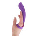 A hand wearing the Simple and True Silicone G-Spot Finger Extender by BMS Enterprises, a purple silicone finger vibrator designed for personal use. The device wraps around the finger with a curved, smooth surface extending outward. The close-up image highlights the ergonomic shape and soft texture of this versatile product.